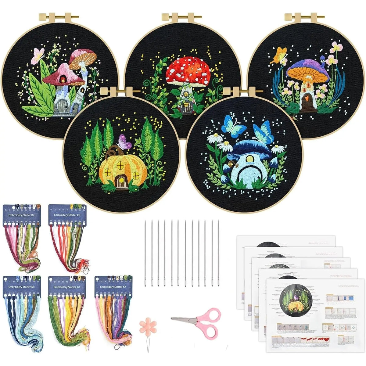 Kit complet de broderie traditionnel avec cinq tambours motifs maisons champignons magiques sur tissu noir echeveaux de fils de couleur aiguilles et ciseaux.