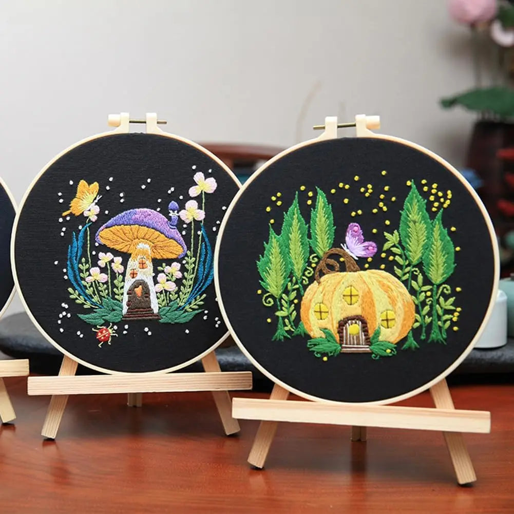 Tambours de broderie termines de style feerique exposes sur de petits chevalets en bois decoratifs.
