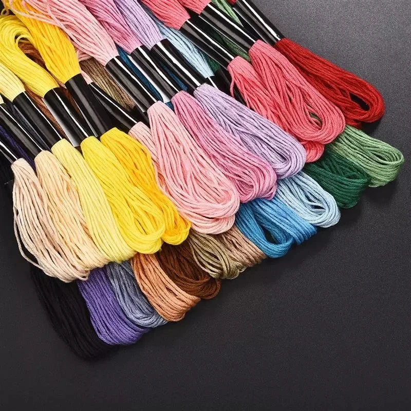 Sélection d'écheveaux de fils de coton colorés alignés sur un plan de travail noir