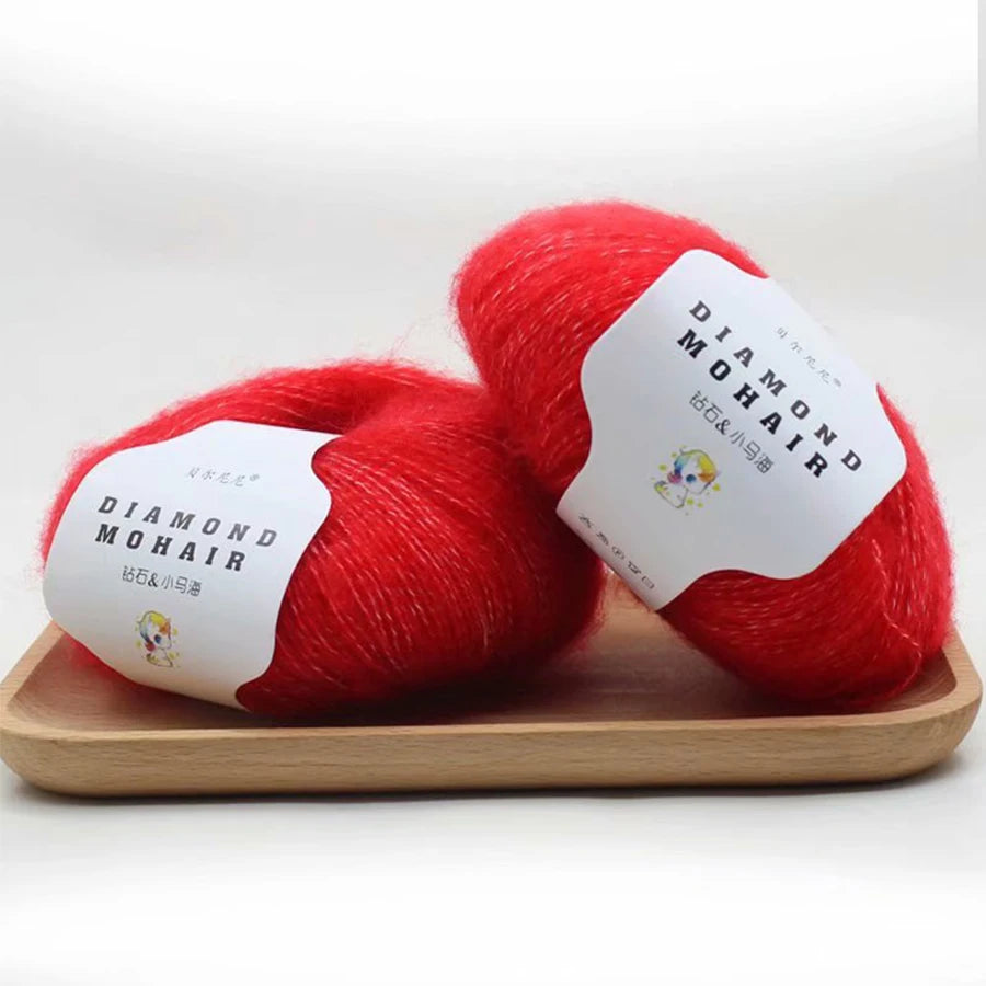Pack de deux pelotes de laine Diamond Mohair couleur rouge vif posées sur un plateau