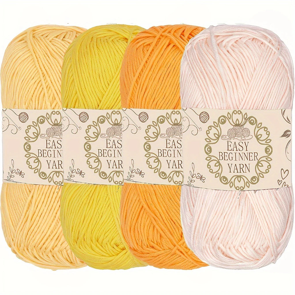 Quatre pelotes de laine de couleurs claires jaune ocre orange pastel et rose nude pour amigurumi