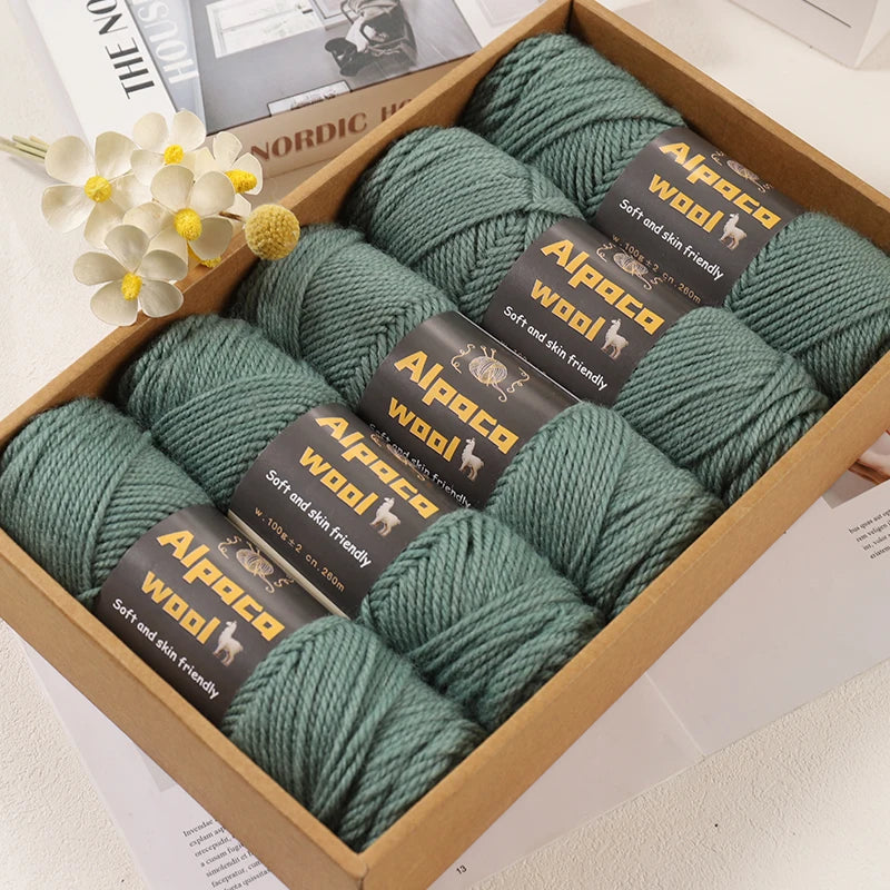 Coffret de rangement contenant cinq pelotes de laine alpaga couleur vert sauge
