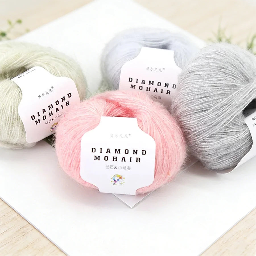 Quatre pelotes de laine mohair duveteuse aux tons pastel rose blanc et vert clair