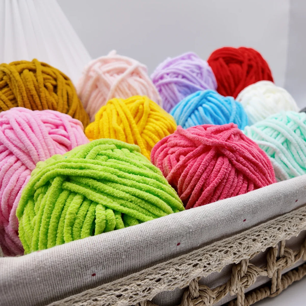 Assortiment de pelotes de fil chenille colorées disposées dans un panier de rangement