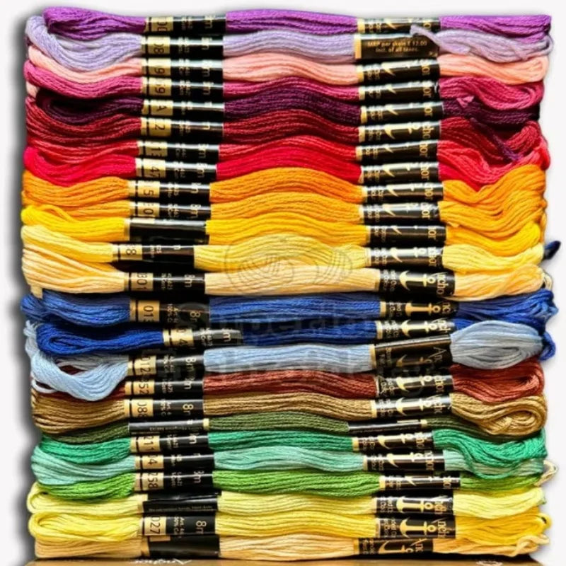Piles d'écheveaux de fils à coudre et broder classés par nuances de couleurs pour l'atelier