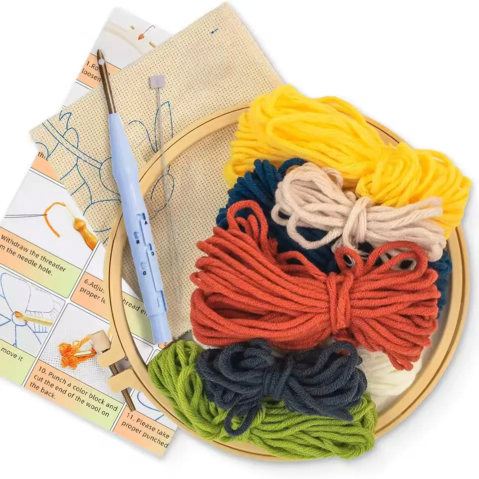 Kit créatif punch needle ouvert avec un tambour en bois contenant des échevettes de fils épais noirs, rouges, jaunes et verts.