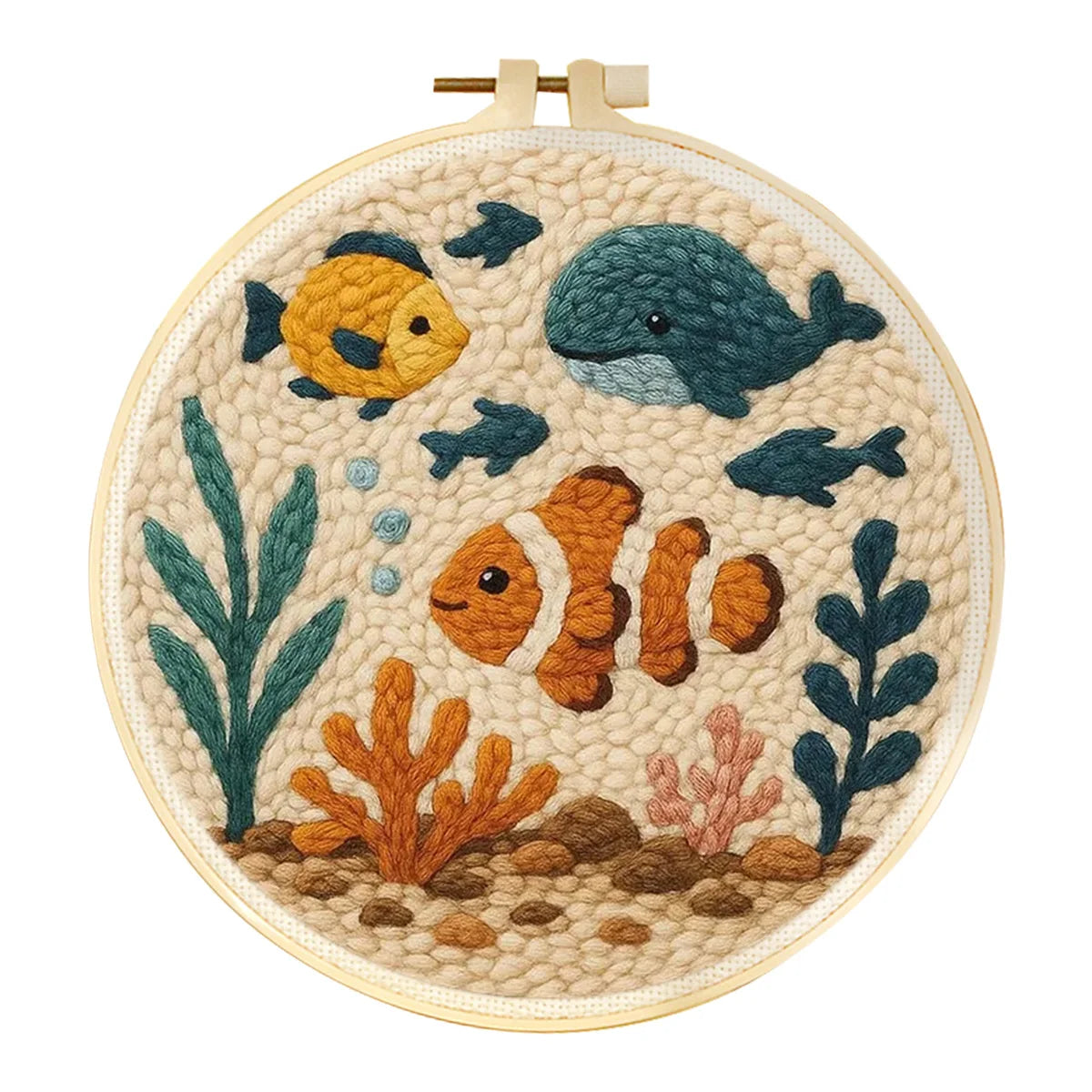 Broderie magique punch needle paysage marin avec un poisson clown orange entouré de récifs de corail et d'algues vertes sur canevas écru.