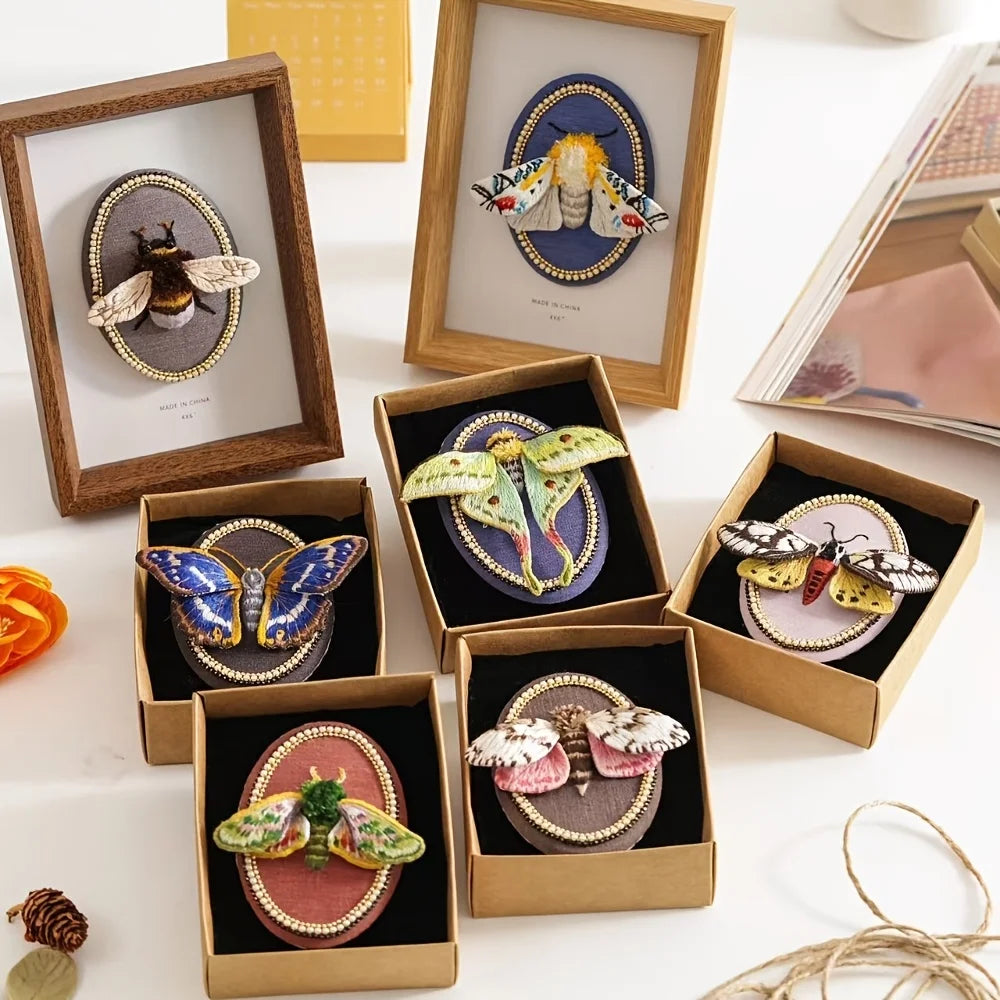 Kits de broderie d’insectes en relief présentés dans de petites boîtes en carton kraft avec leurs cadres ovales décoratifs.