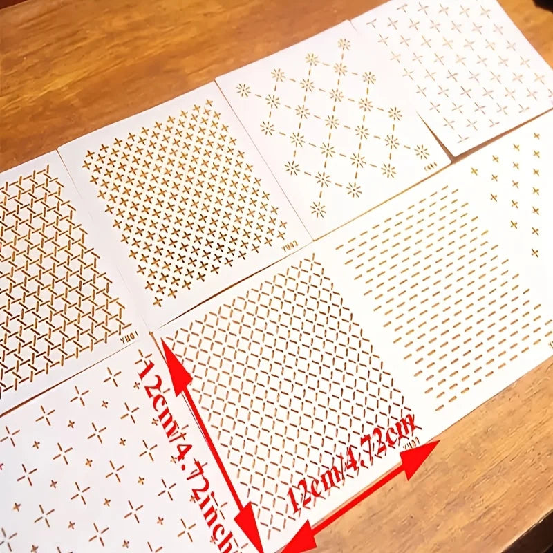 Plaques de stencils pour broderie point de croix Sashiko de dimensions 12 par 12 cm disposees a plat sur une table en bois.