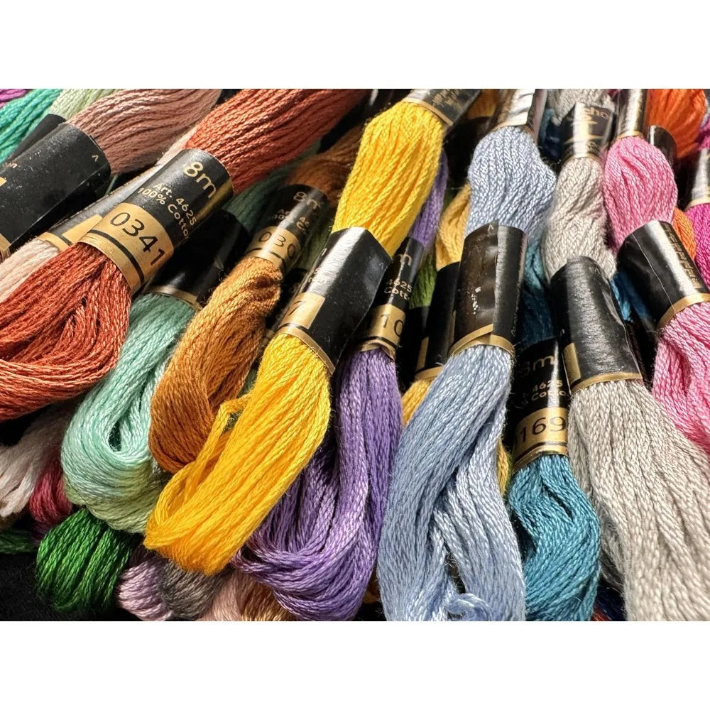 Gros plan sur des écheveaux de fils à broder colorés avec bagues de référence noires